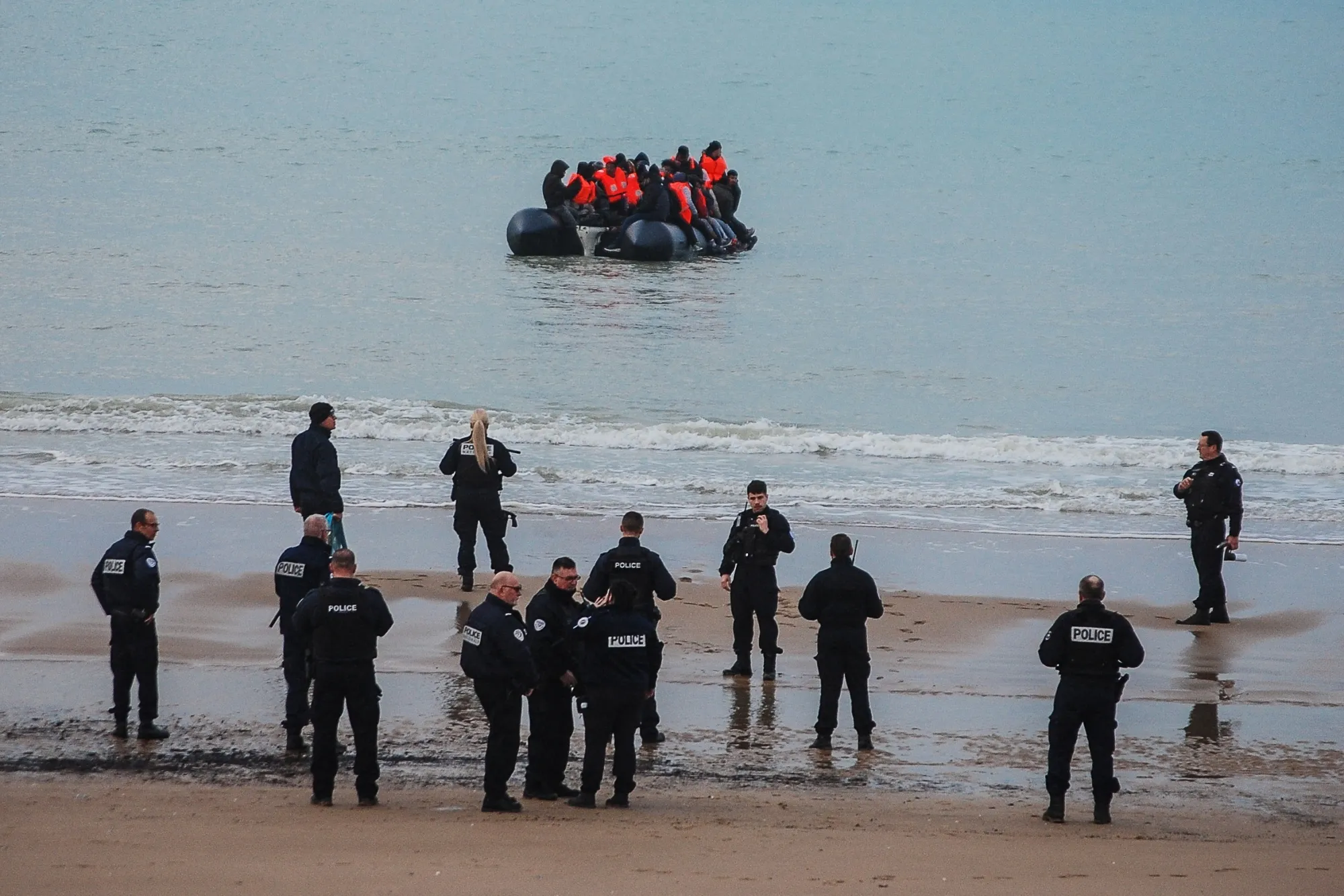 Policemen stand on the shore as migrants attempt to cross the English Channel to reach Great Britain, on Jan. 15.&nbsp;