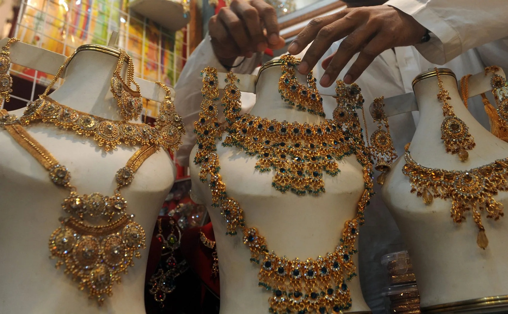 A man arranges gold jewelry at&nbsp;his shop in Karachi.