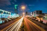 The Kingdom Tower, operated by Kingdom Holding Co., left, stands alongside the King Fahd highway, illuminated by the light trails of passing traffic, in Riyadh, Saudi Arabia.