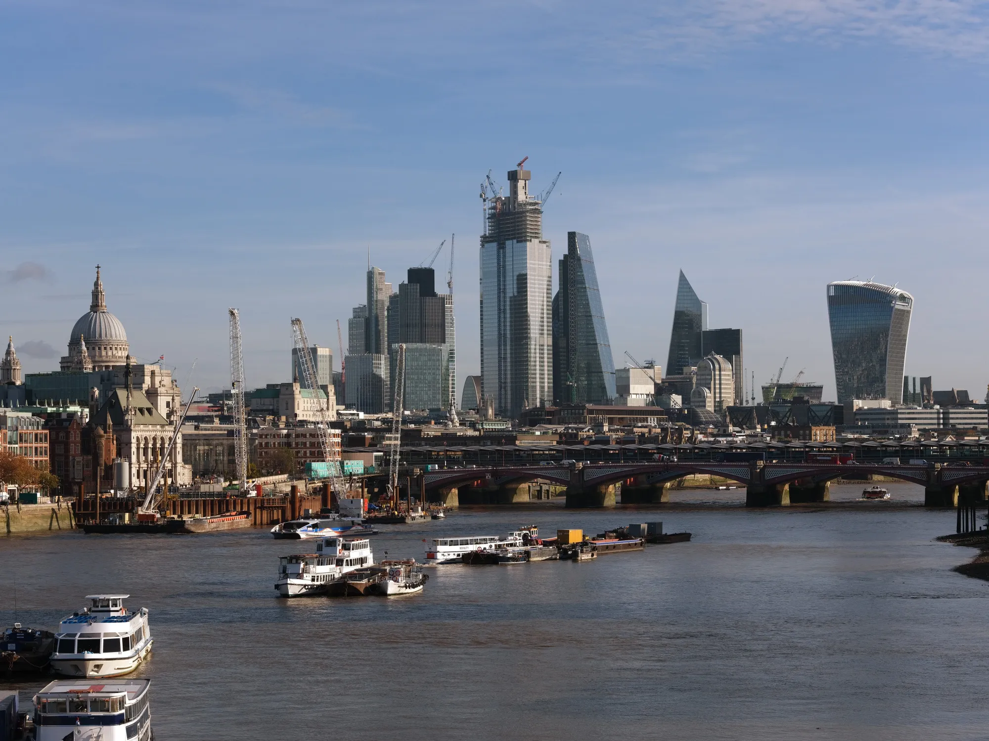 The dome of St. Paul's Cathedral, left, and skyscrapers in the City of London, including 20 Fenchurch Street, also known as the "Walkie-Talkie," 22 Bishopsgate office tower, the Leadenhall building, also known as the "Cheesegrater", and The Scalpel stand beside the River Thames in London, U.K., on Wednesday, Nov. 14, 2018. The City of London averted one disaster with the draft Brexit deal announced Wednesday, but the bottom line is that banks, brokers and asset managers will continue to prepare for the talks going off the rails.