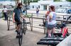 A worker wearing a protective mask assists customers at a bike repair shop in Austin, Texas, U.S., on Thursday, June 25, 2020. 