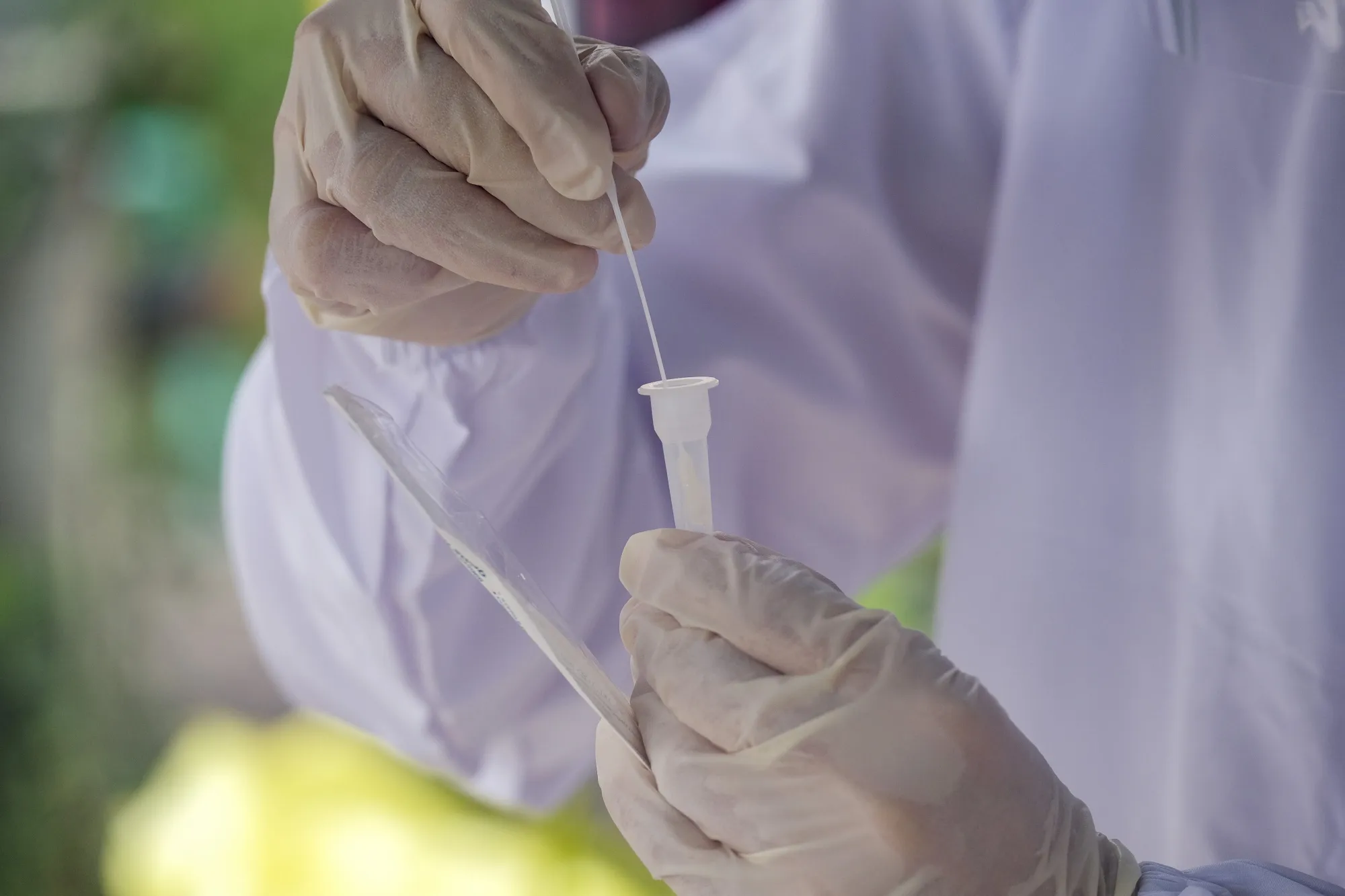 A healthcare worker processes a sample for a Covid-19 antigen test.