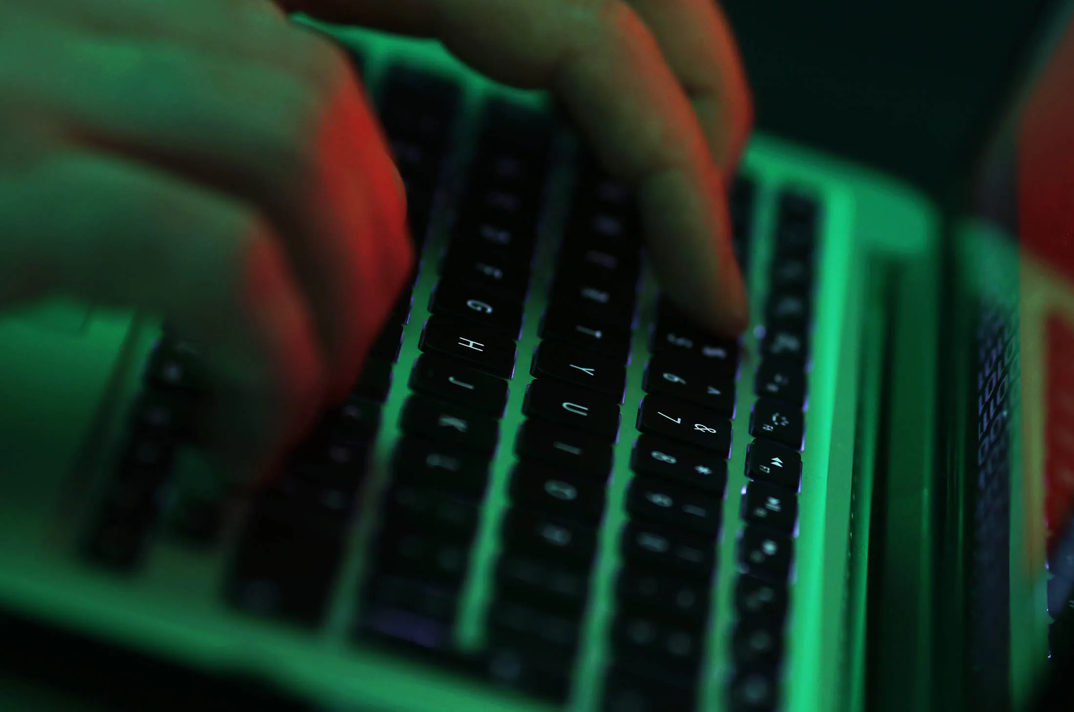 Green light illuminates the keyboard of laptop computer as a man enters the data using the computer keyboard in this arranged photograph in London, U.K., on Wednesday, Dec. 23, 2015. The U.K.s biggest banks fear cyber attacks more than regulation, faltering economic growth and other potential risks, and are concerned that a hack could be so catastrophic that it could lead to a state rescue, according to a survey.
