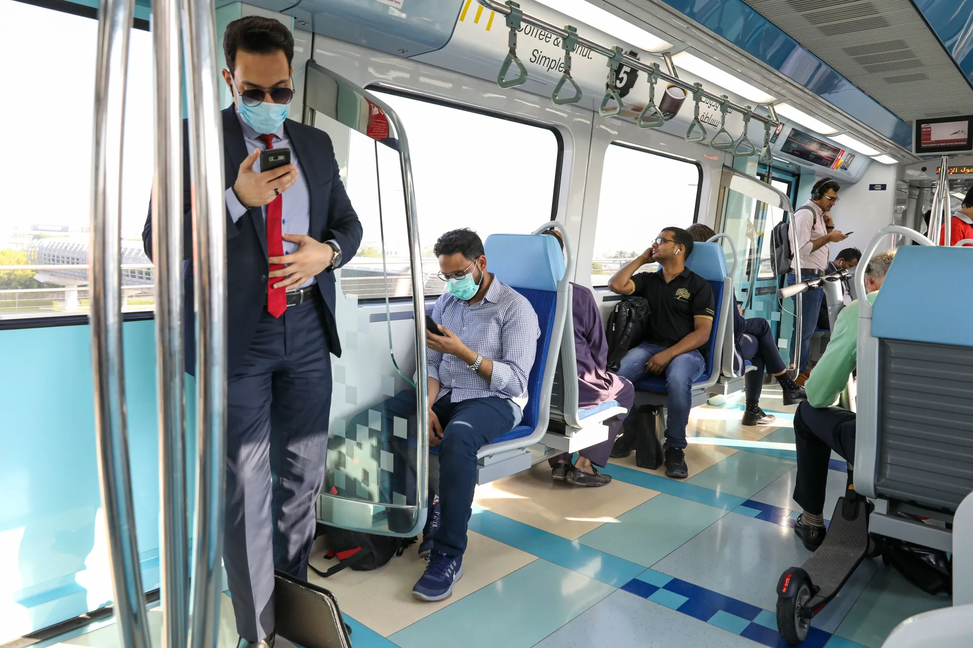 Commuters use smartphones on the metro in Dubai, United Arab Emirates.