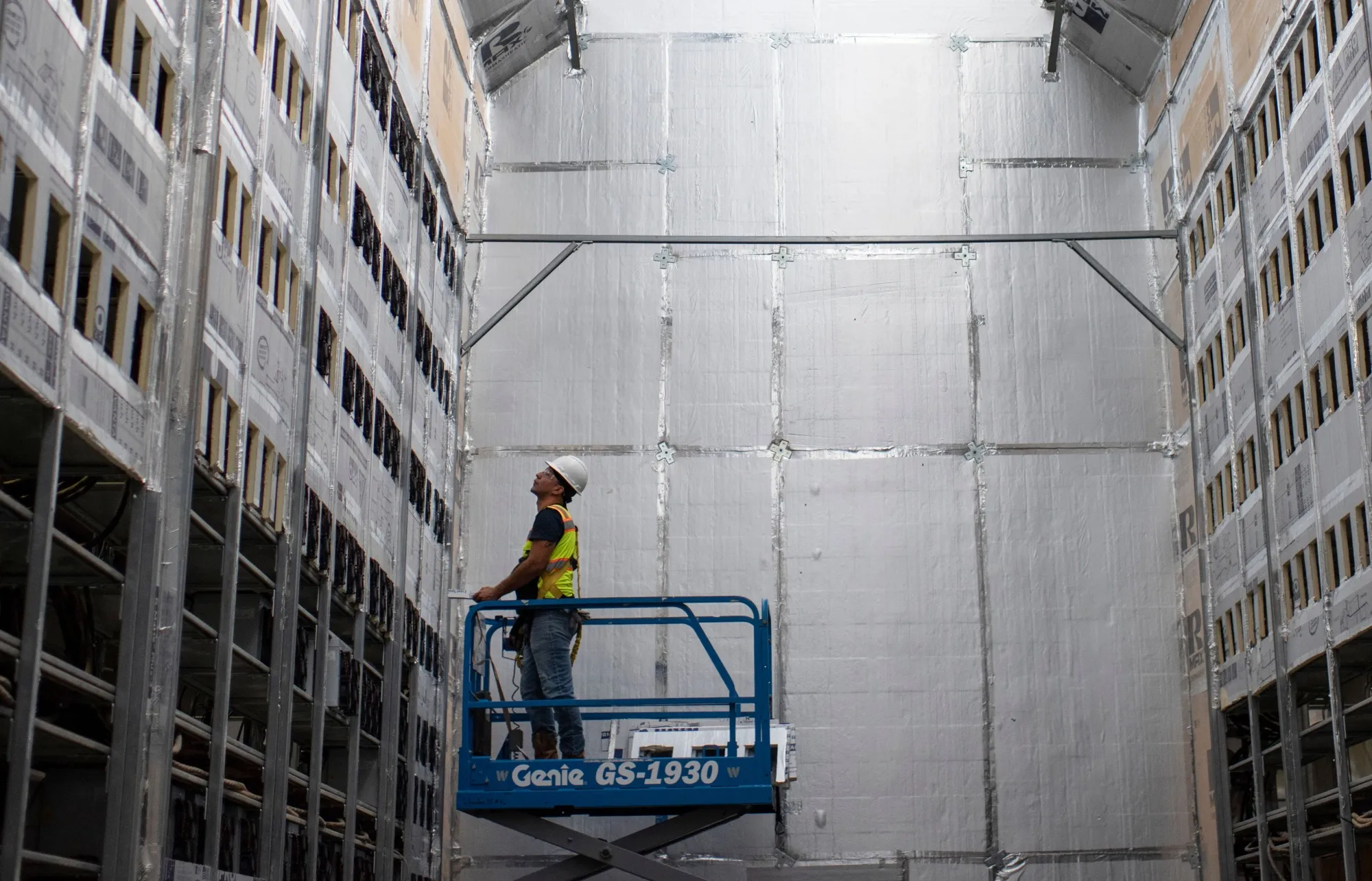 A worker installs a row of Bitcoin mining machines in Rockdale, Texas.