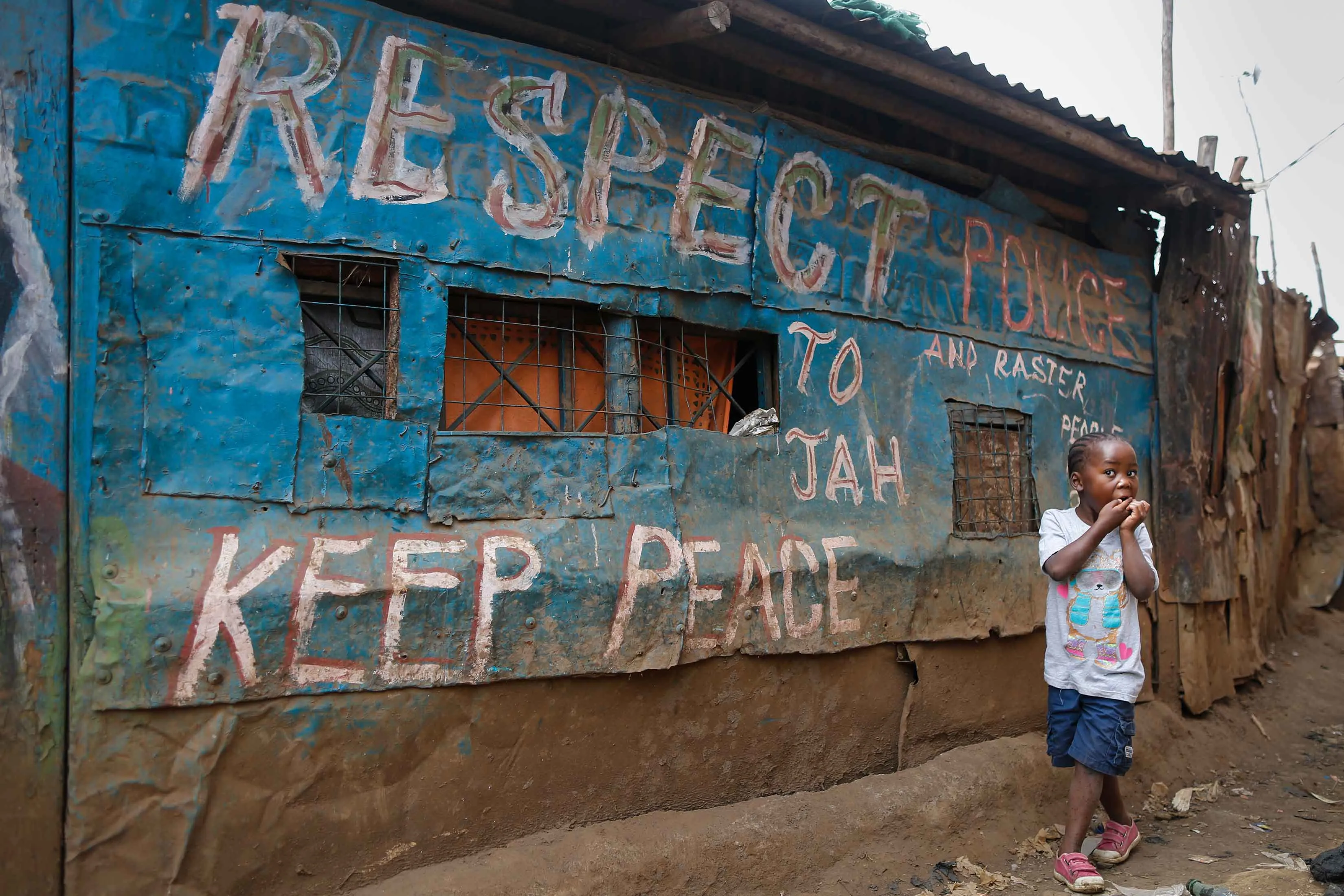 A girl walks in front of a pub painted with messages during the 2007-08 general elections in Kenya.