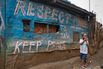 A girl walks in front of a pub painted with messages during the 2007-08 general elections in Kenya.