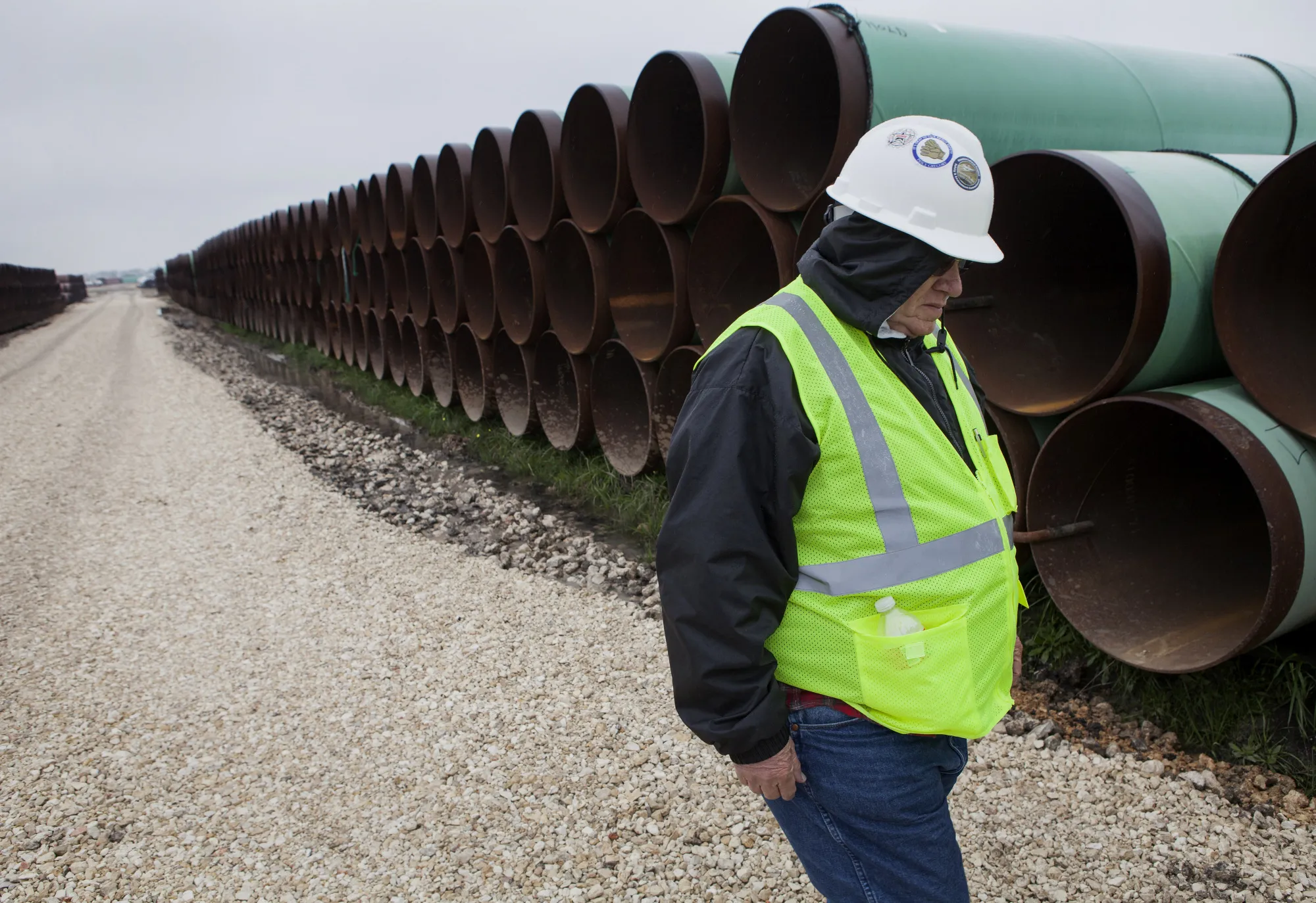A worker walks through the pipe yard for TransCanada's Houston Lateral Project in Mont Belvieu, Texas, about 30 miles east of Houston on Wednesday, March 5, 2014.
