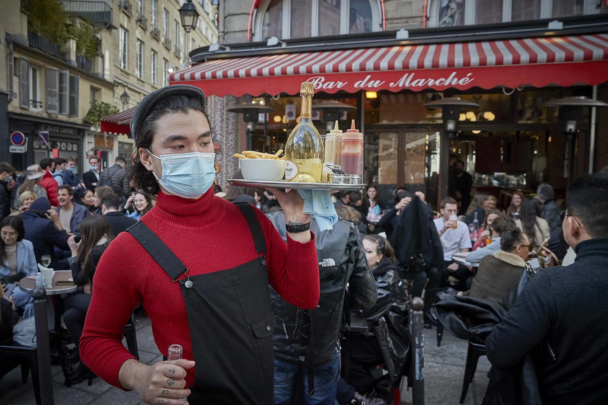 A waiter serves customers at a restaurant&nbsp;in Paris.