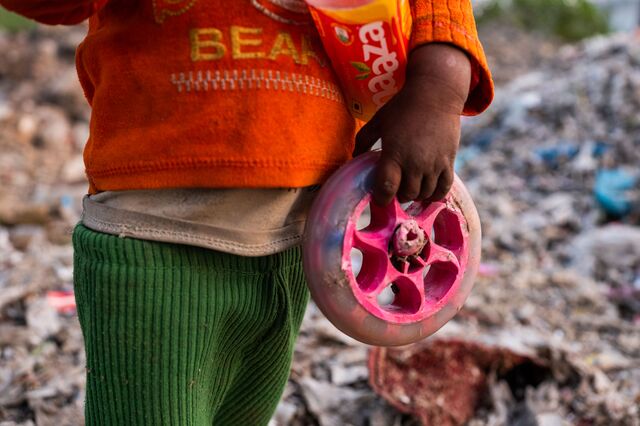 A child holds a discarded toy at a plastic scrap contractors yard, in Muzaffarnagar District, Uttar Pradesh, India, on Thursday, Nov. 17, 2022. Photographer: Prashanth Vishwanathan/Bloomberg