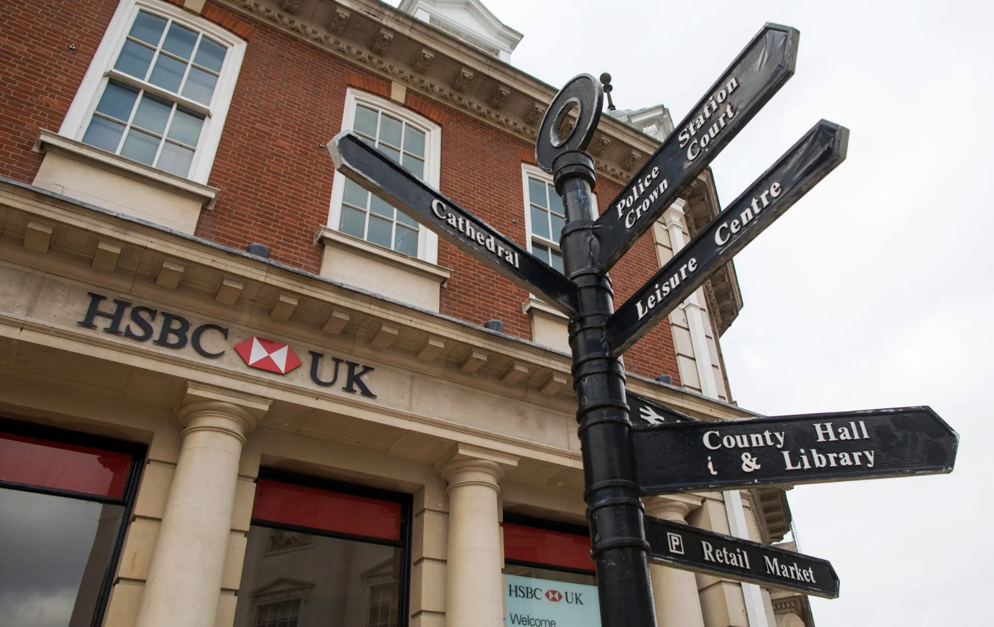 Street signs outside an HSBC Holdings Plc bank branch in Chelmsford, U.K., on Thursday, Feb. 11, 2021. The U.K. economy grew at double the pace expected in the fourth quarter, showing signs of resilience to coronavirus restrictions at the end of a year that delivered the worst recession since 1709.