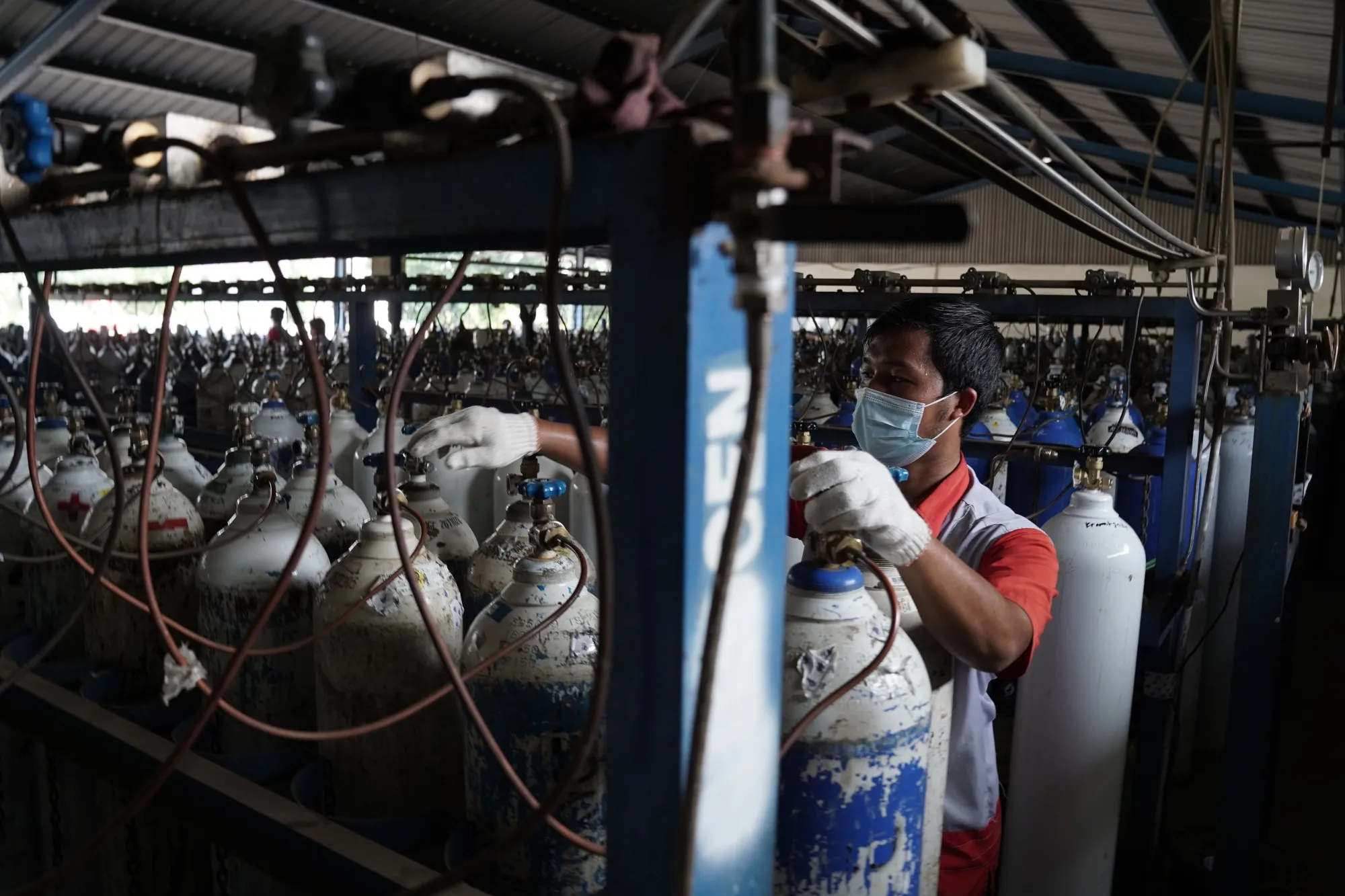 A worker refills oxygen tanks for hospitals at a distribution facility in Jakarta, on July 6.