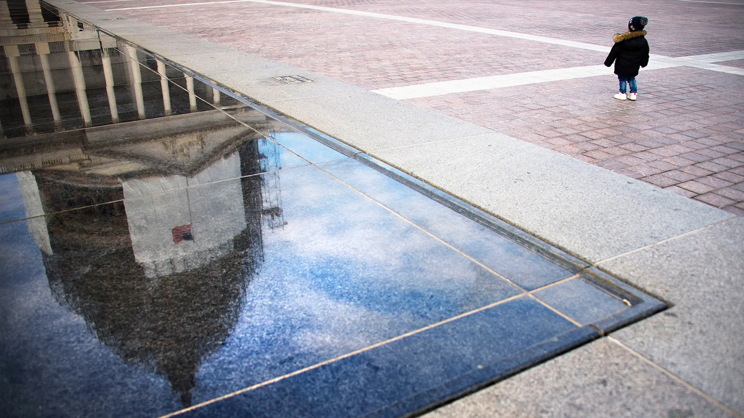 A young boy looks up at the US Capitol under construction in Washington, DC, December 30, 2014.
