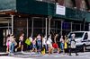 Pedestrians wearing protective masks cross a street in the Soho neighborhood of New York, U.S., on Thursday, Aug. 6, 2020. 