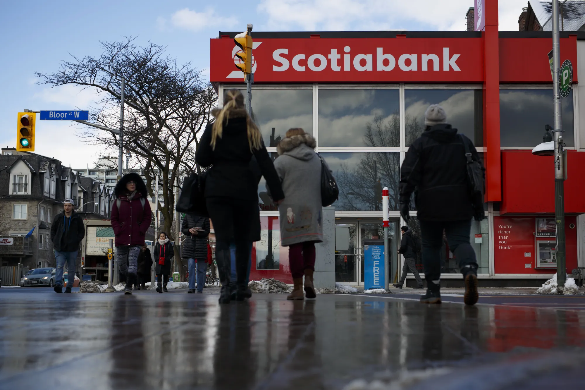 Pedestrians pass a Bank of Nova Scotia branch in Toronto.