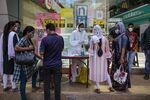 A healthcare worker talks to people at a Covid-19 test site set-up outside a mall in Mumbai&nbsp;on&nbsp;March 31.&nbsp;