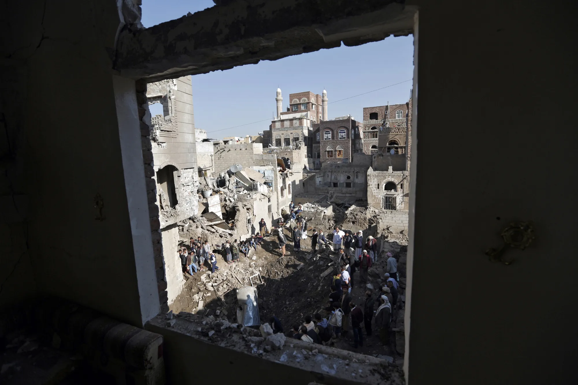 People look at the damage in the aftermath of an air strike in the Yemeni capital of Sanaa on Nov. 11, 2017.
