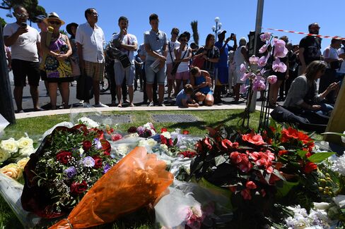 People stand in front of flower tributes in Nice on July 15.