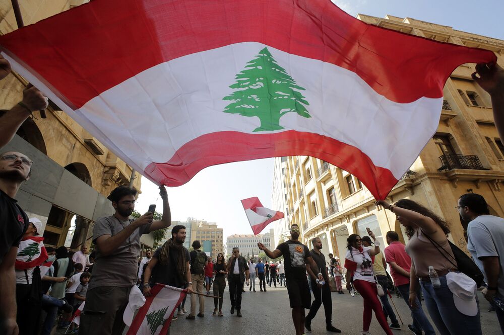 Protesters wave the national flag in downtown Beirut on Oct. 19. 