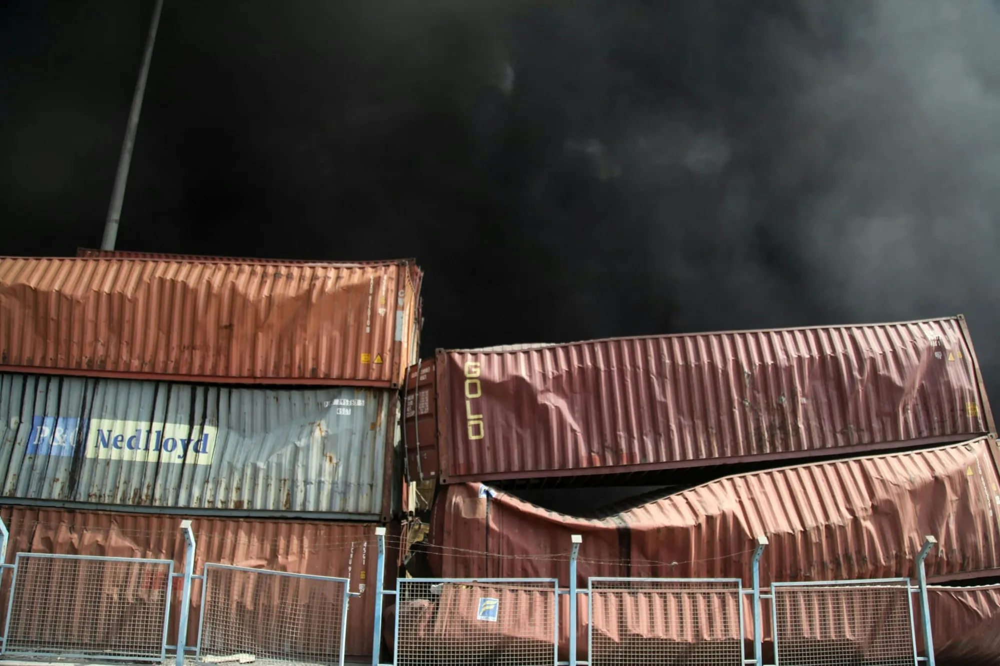 Black smoke rises behind damaged containers following an explosion at the Shahid Rajaee port dock on April 26.