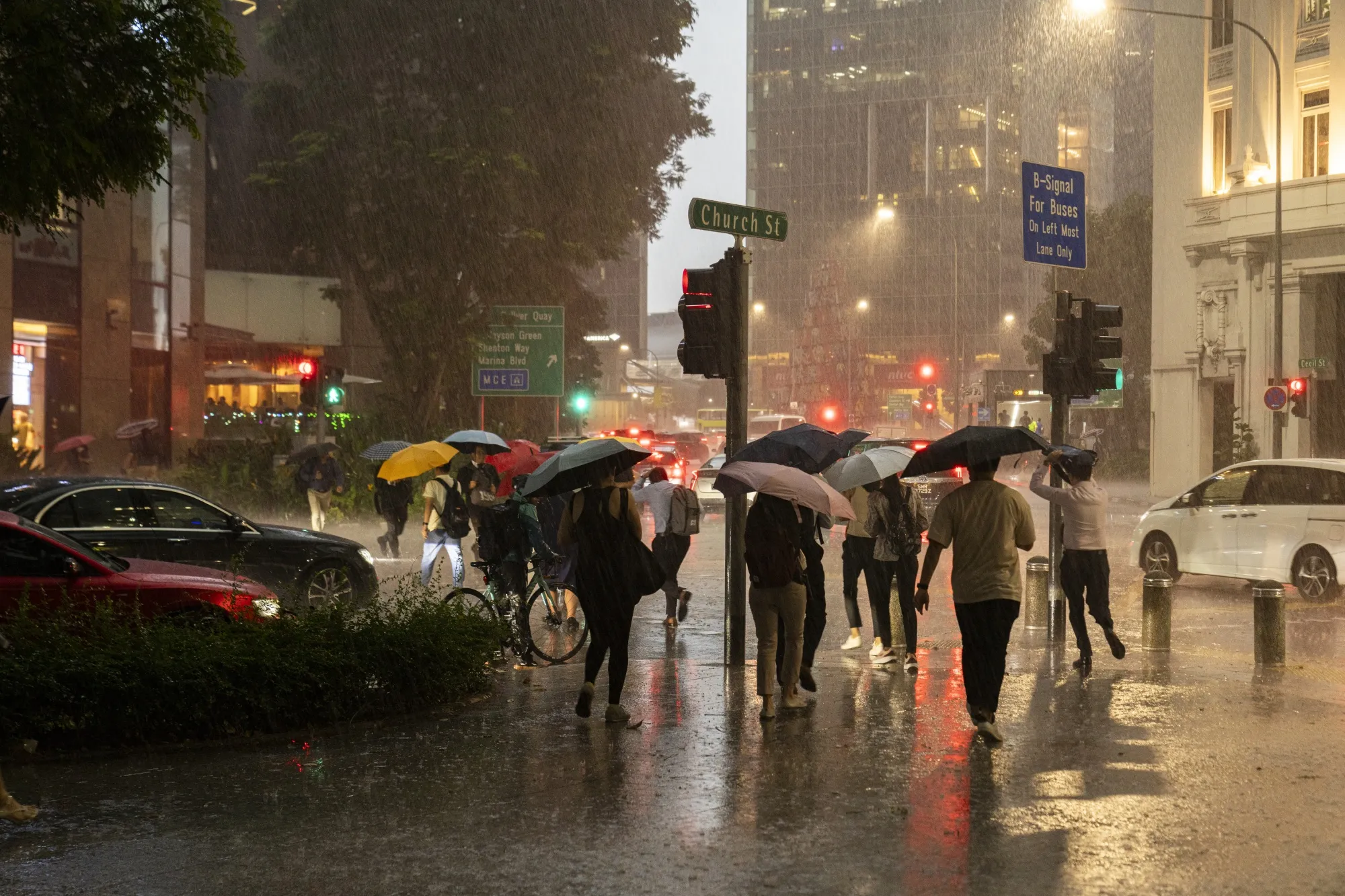 Evening commuters walk through the rain in Singapore.