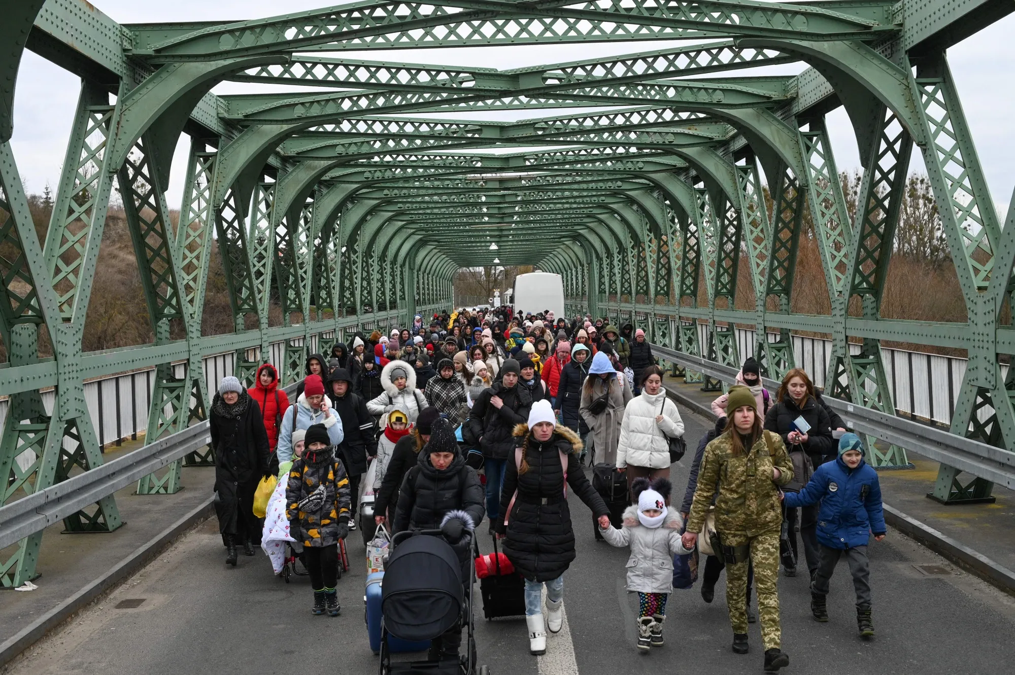 Ukrainian refugees walk a bridge at the border with Poland&nbsp;on March 6.&nbsp;