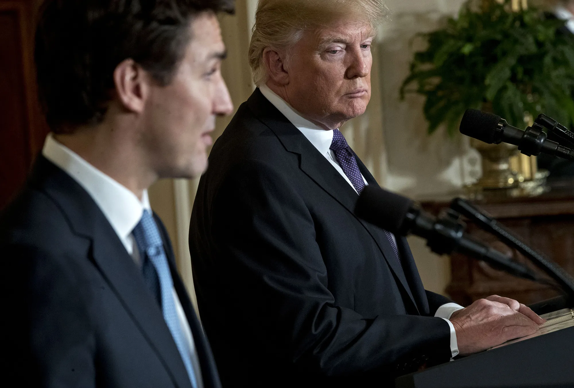 U.S. President Donald Trump listens as Justin Trudeau, Canada's prime minister, left, speaks during a news conference in the East Room of the White House in Washington, D.C., on Feb. 13, 2017.
