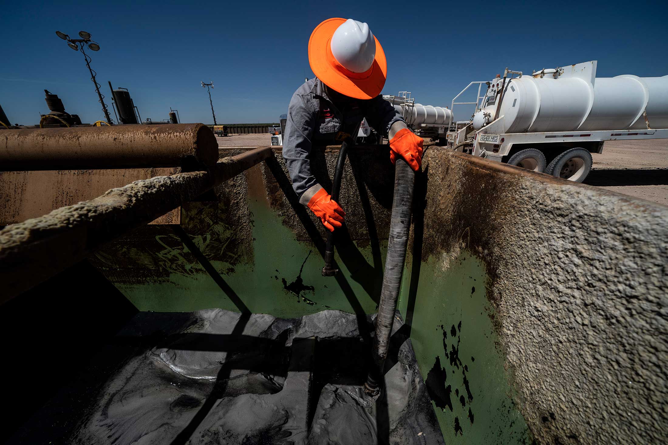 Pekerja mengekstraksi minyak dari sumur di Permian Basin di Midland, Texas.