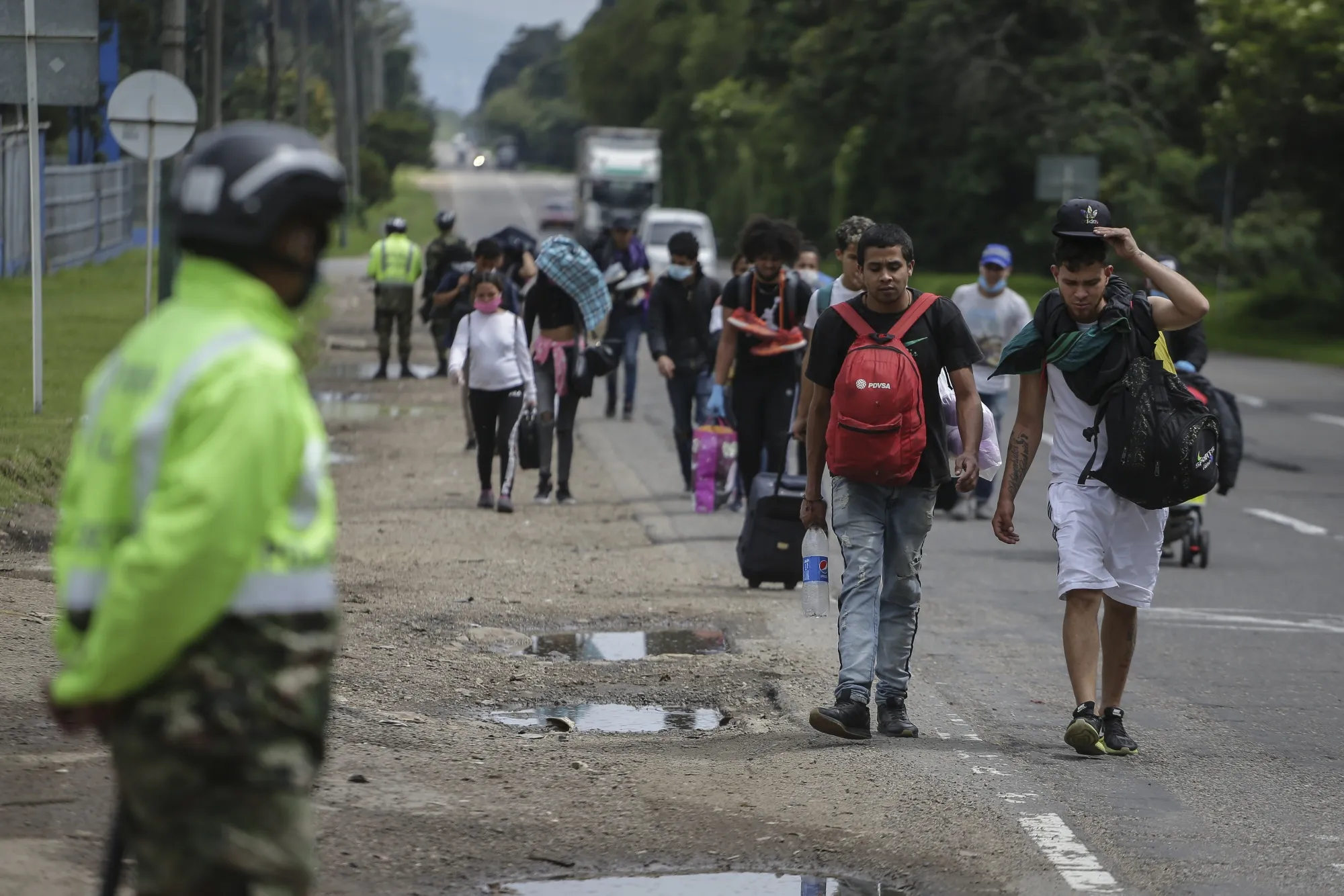 Venezuelan migrants walk on the side of a road towards a military checkpoint on their way back to Venezuela on April 3.