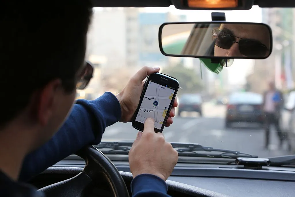 A Snapp driver checks the app on his mobile in Tehran.