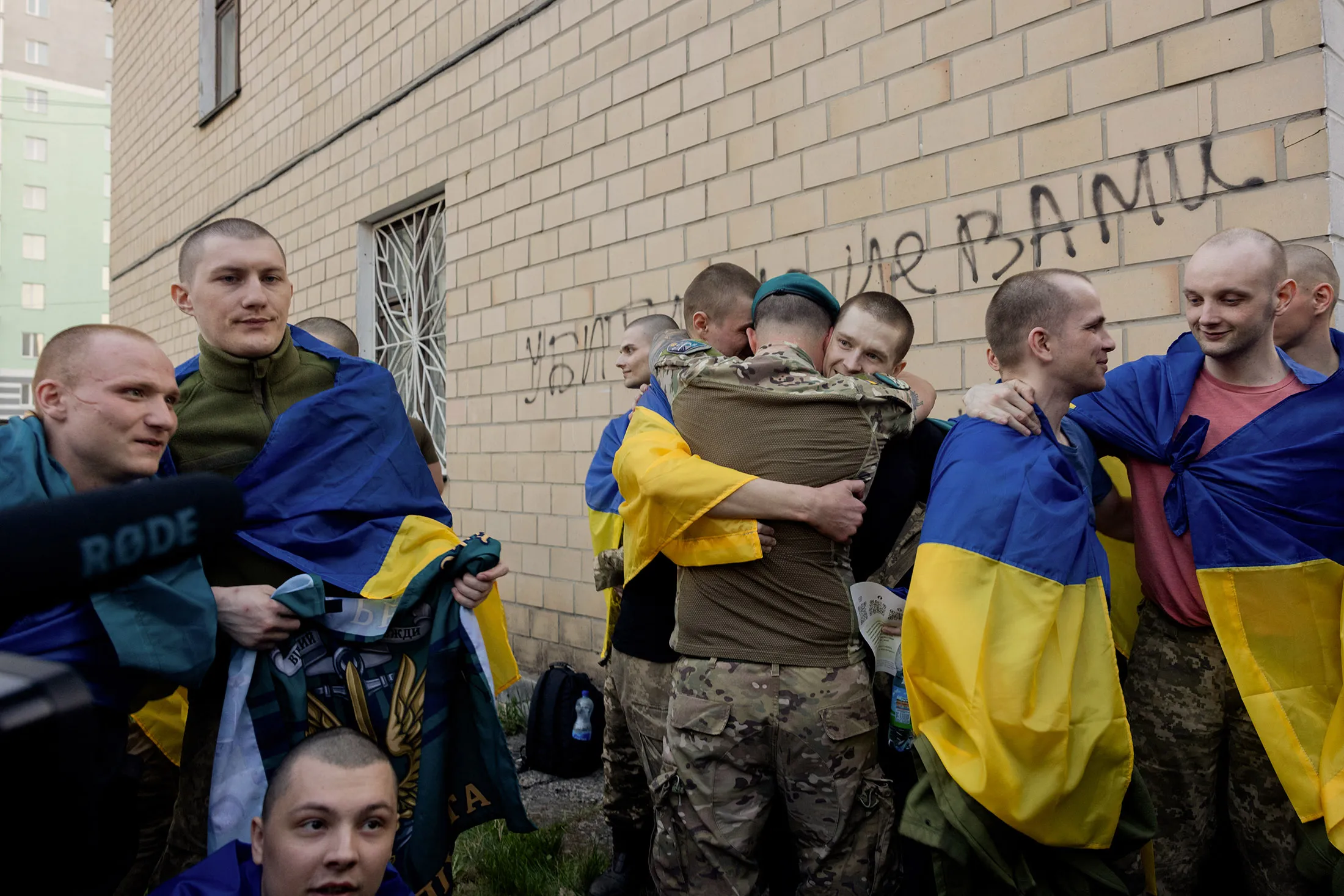 Freed Ukrainian prisoners hug after their exchange at an undisclosed location in Ukraine on April 19.