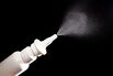 Close-up of nasal drug spraying on black background