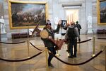 Adam Johnson&nbsp;carries the lectern of House Speaker&nbsp;Nancy Pelosi through the Capitol rotunda&nbsp;on Jan. 6, 2021.