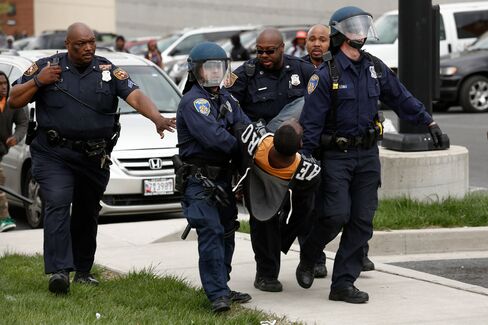 Baltimore Police officers arrest a man during a skirmish with demonstrators after the funeral of Freddie Gray on April 27, 2015.