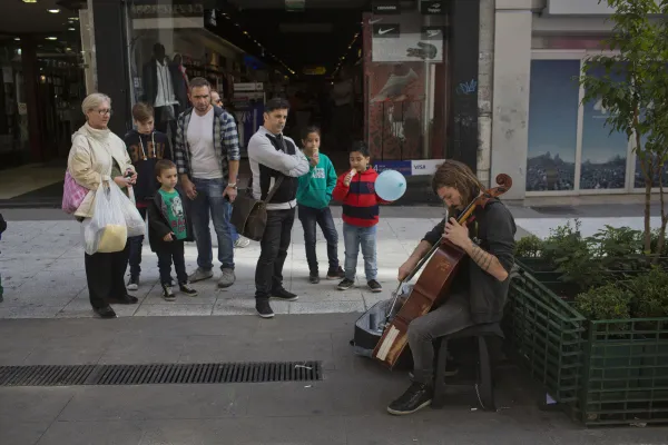 Pedestrians watch a street performer play cello on Florida Street, one of the main commercial thoroughfares, in Buenos Aires.