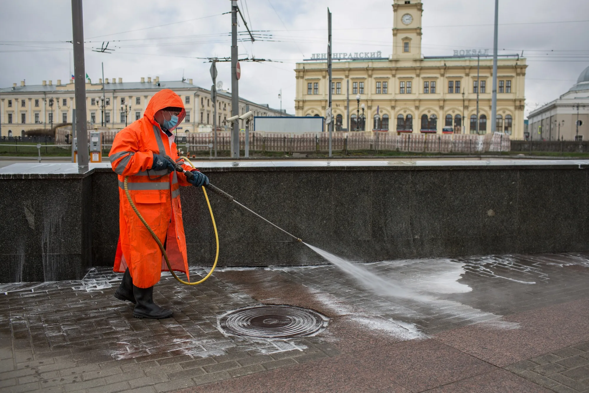A municipal worker uses a high pressure water spray to clean the sidewalk in Moscow on April 15.
