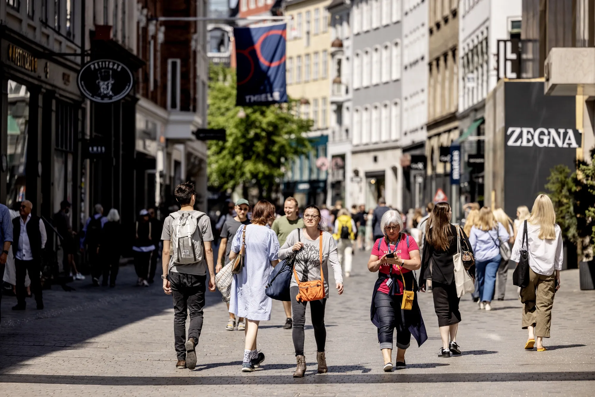 Shoppers walk through the Kobmagergade pedestrianized retail street in Copenhagen, Denmark.