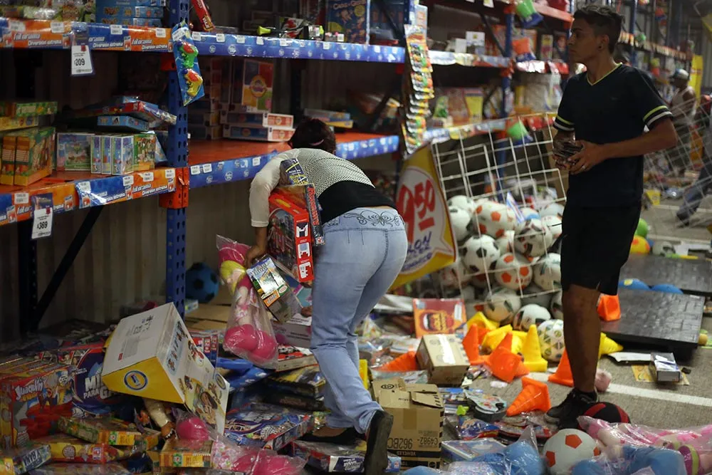 People pick up toys as they loot a store during a protest in the port of Veracruz, Mexico, on Jan. 4, 2017, related to a 20 percent gasoline price increase.
