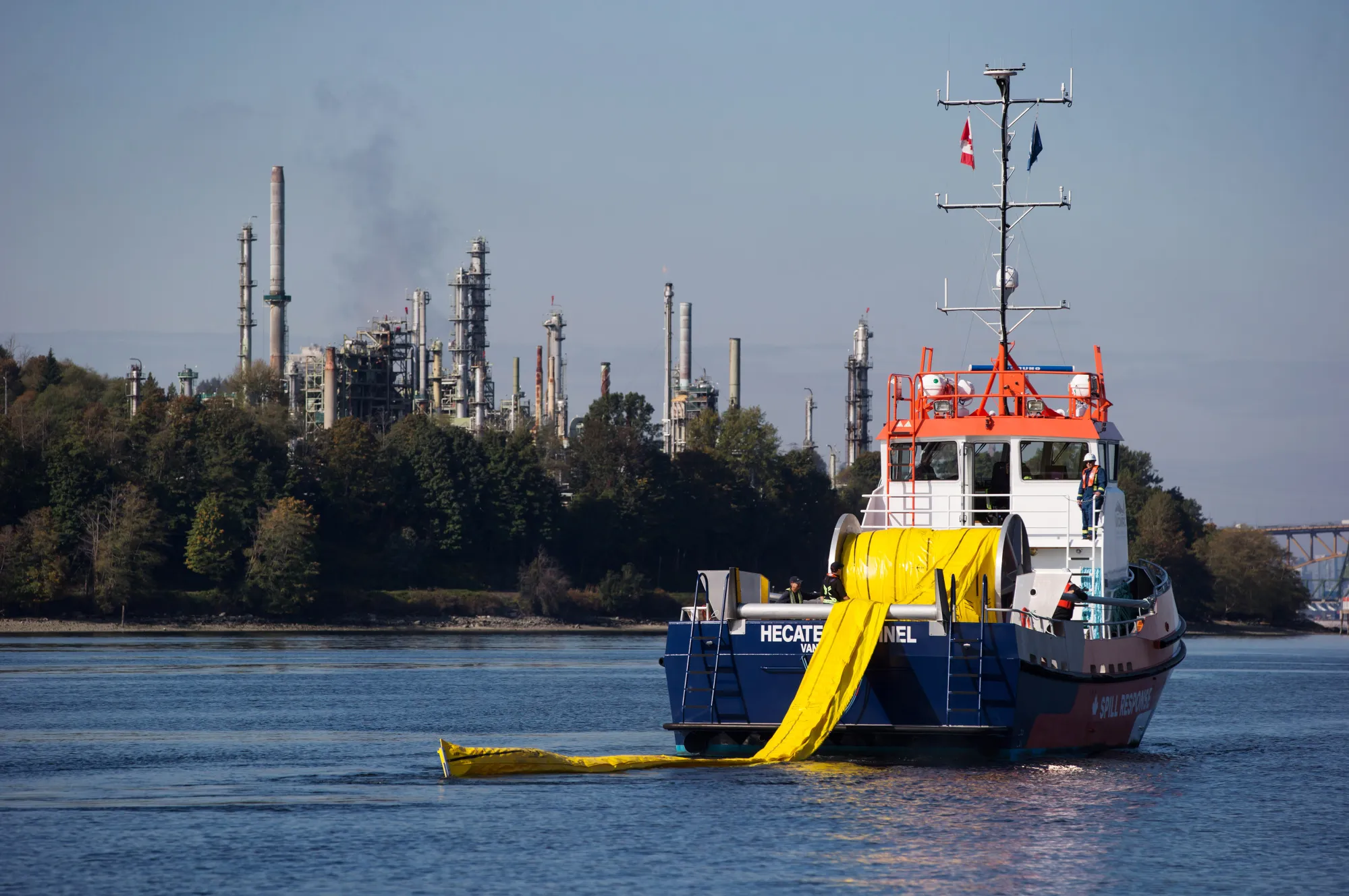 A spill-response boat deploys a boom near a refinery at the end of the Trans Mountain pipeline in Burnaby, British Columbia.
