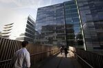 Pedestrians are seen walking across a bridge at the U.K. headquarters of Nomura Asset Management Ltd, right, part of the Nomura Holdings Inc group, in London, U.K.