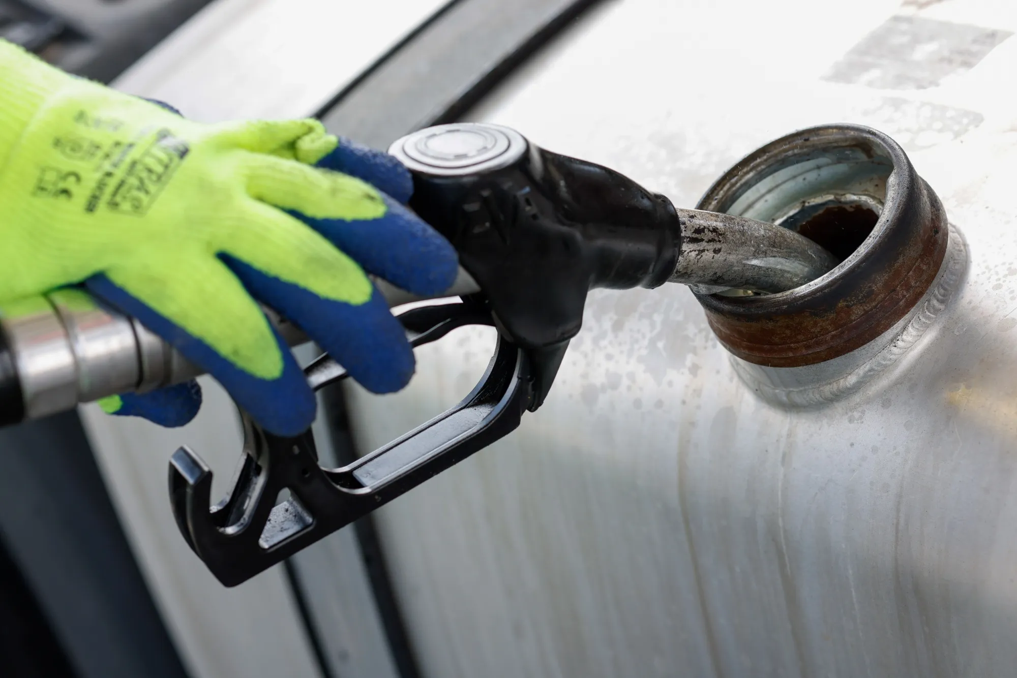 A worker fills up a truck with diesel fuel.