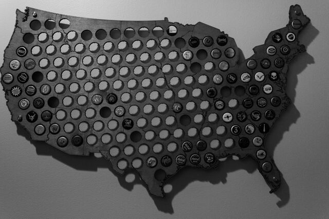 A wooden outline of the United States with local regional beer caps per state hangs on the wall of Kosareva's home. 
