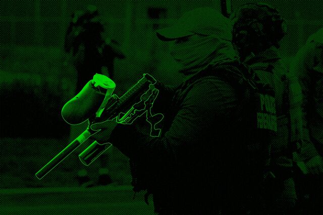 An immigration officer carries a pepper ball gun while patrolling in the Chicago area