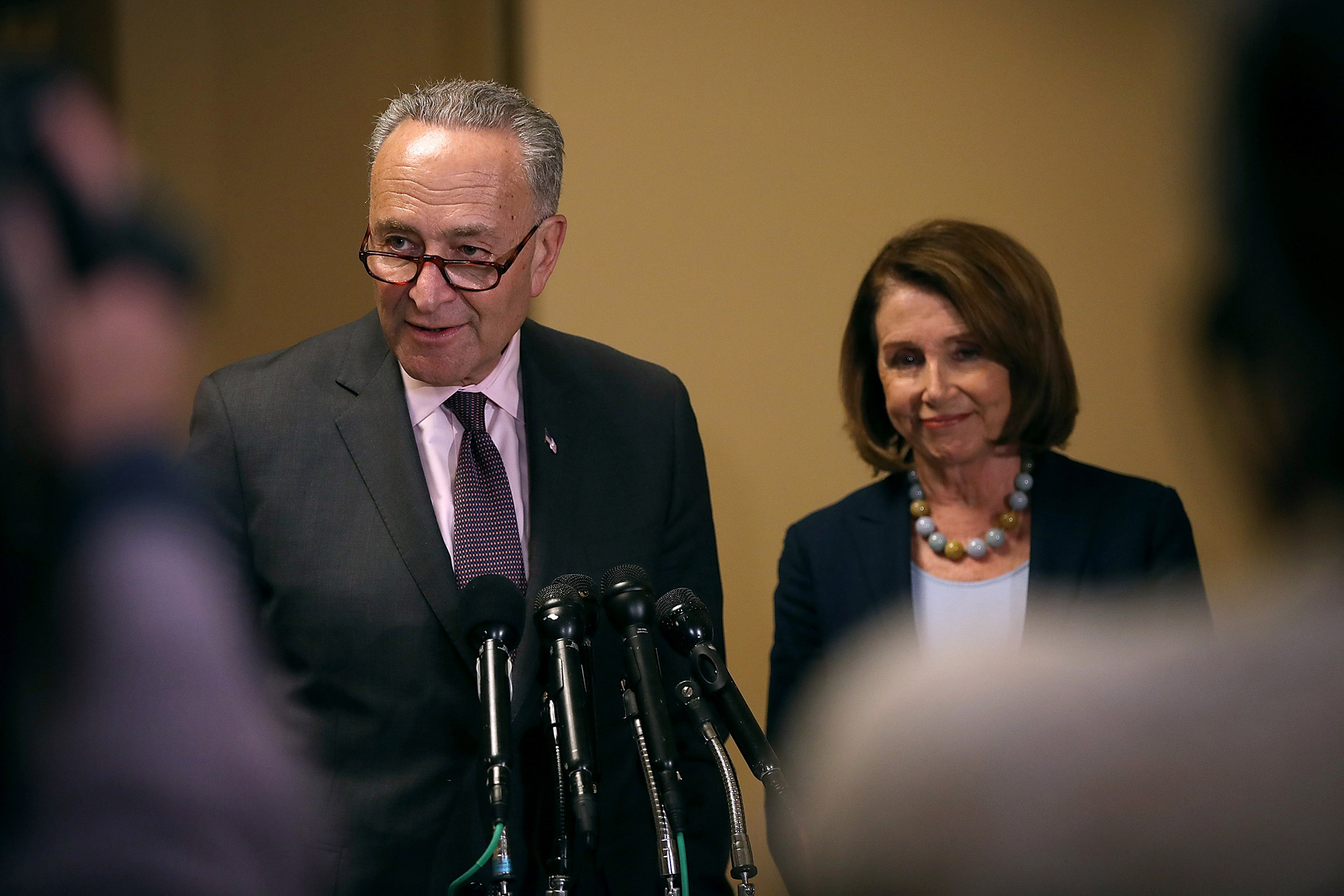 Senate Minority Leader Charles Schumer speaks as House Minority Leader Nancy Pelosi looks on during a news conference at the U.S. Capitol.
