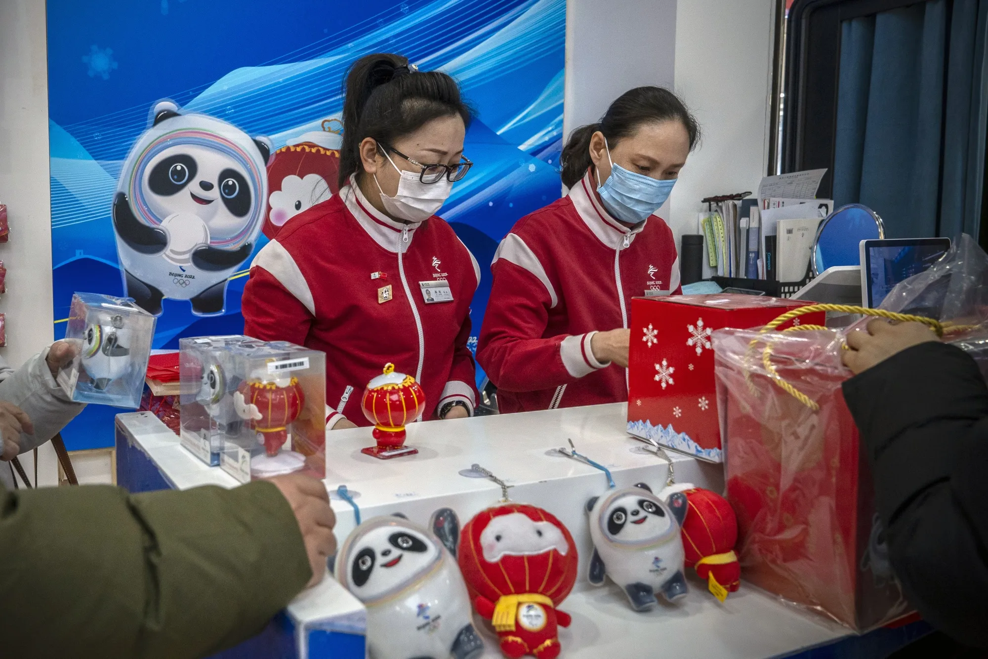 Sales assistants serve customers inside a store selling Beijing 2022 Winter Olympic and Paralympic Games merchandise in Beijing on Jan. 7.