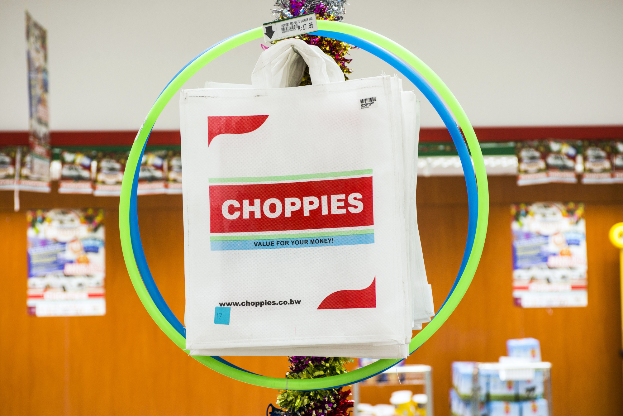 Choppies branded long-life shopping bags hang on display inside a Choppies supermarket.