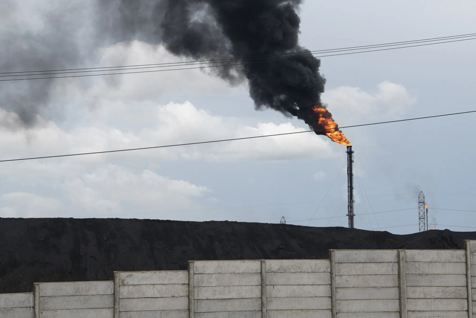 Gas flares behind a coking coal pile at the Jose Antonio Anzotegui Petrochemical Complex in Barcelona, Anzoategui state, Venezuela, on Monday, May 22, 2023. Venezuela’s Oil ministry published oil and gas reserves for years 2019 through 2022, according to a decree in the official gazette dated May 9.