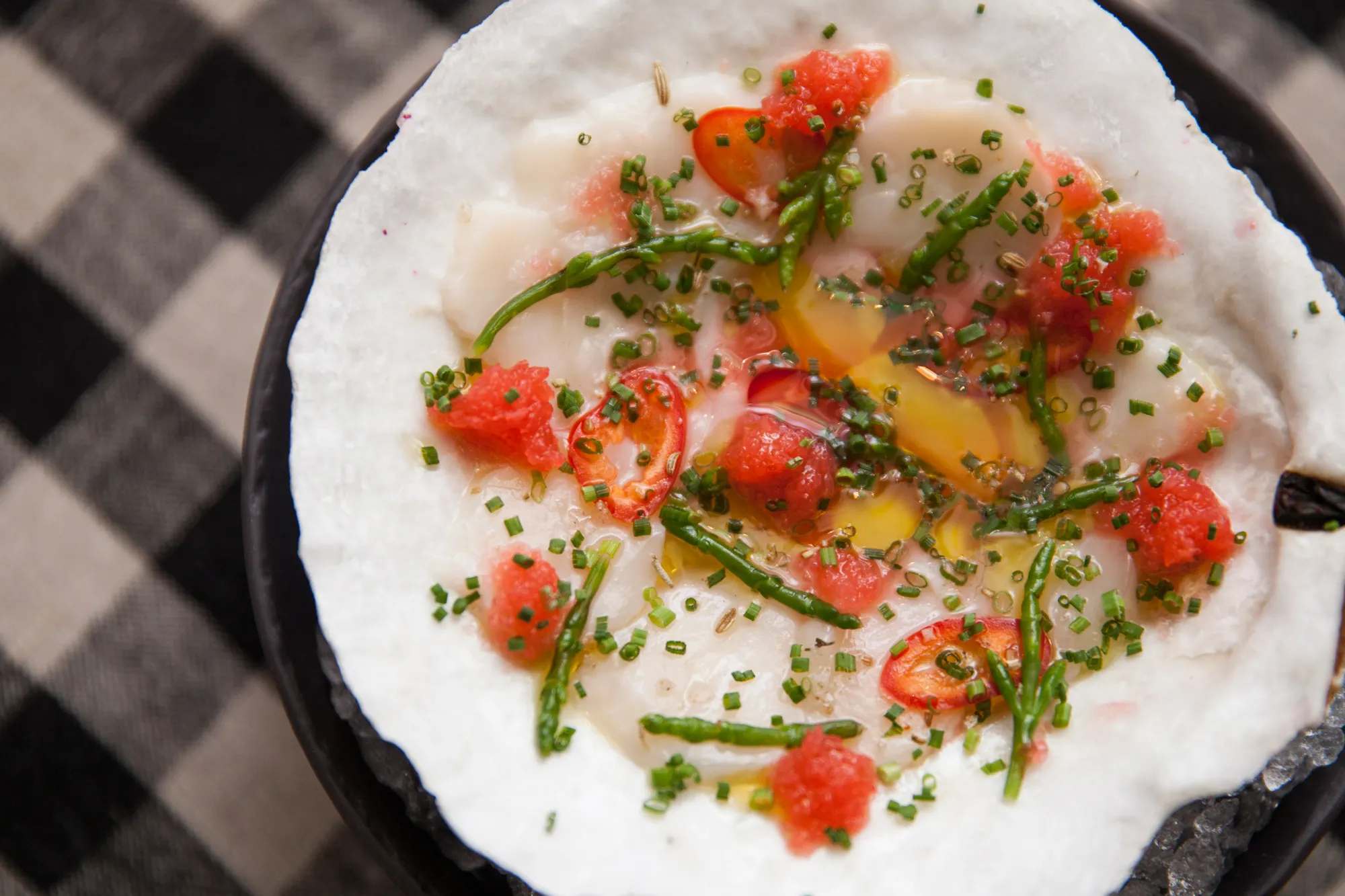 At Upland, which opened in October, Justin Smillie is serving delicious fare like this just-shucked scallop with chile, olive oil, and fermented radish. Photographer: Virginia Rollison/Bloomberg