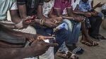 People use their mobile phones while waiting to board a ferry boat in Abidjan, Ivory Coast.
