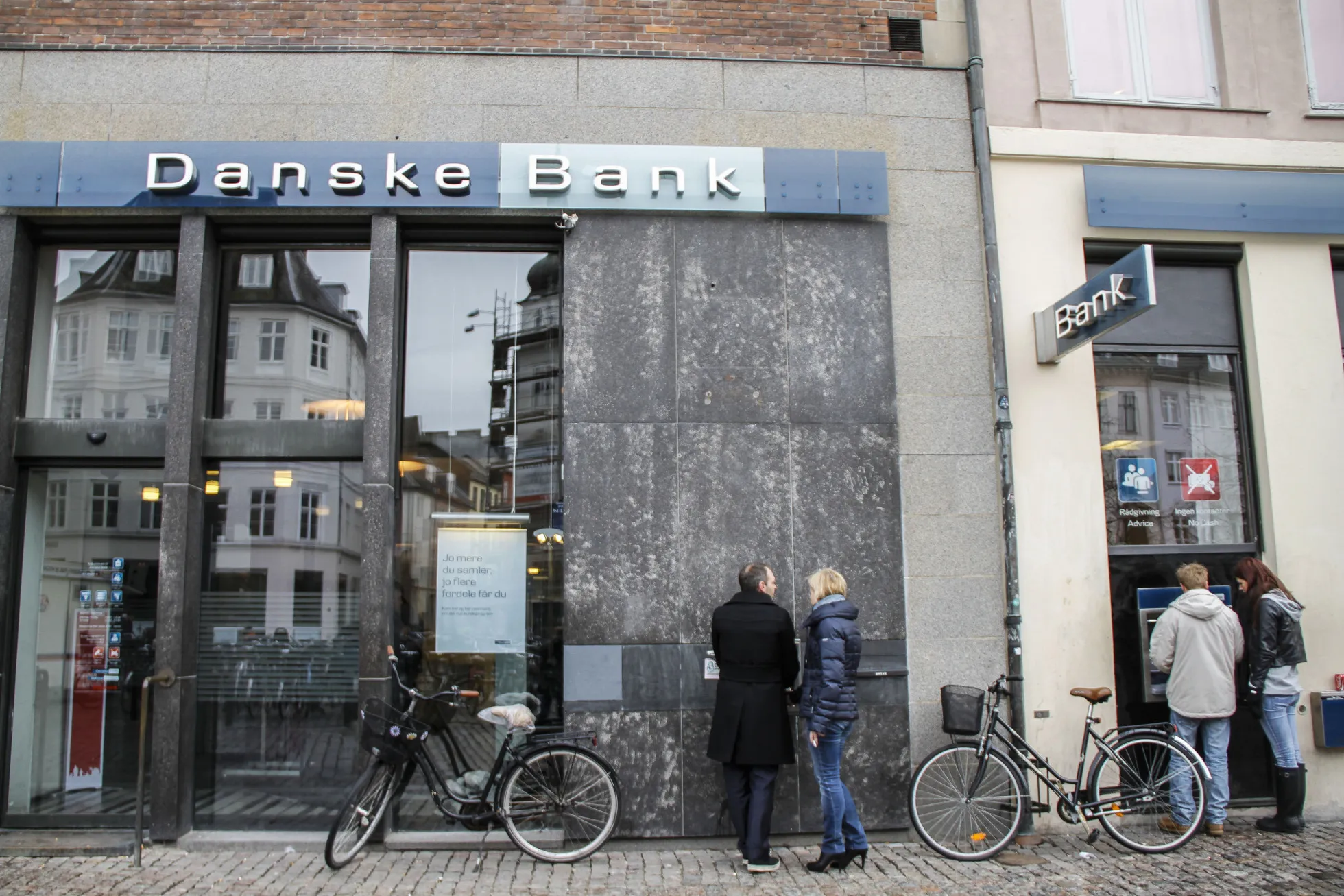 Customers use automated teller machines (ATM) outside a Danske Bank A/S branch in Copenhagen.